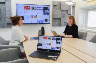 2 Women Sitting in a High-Tech Conference Room